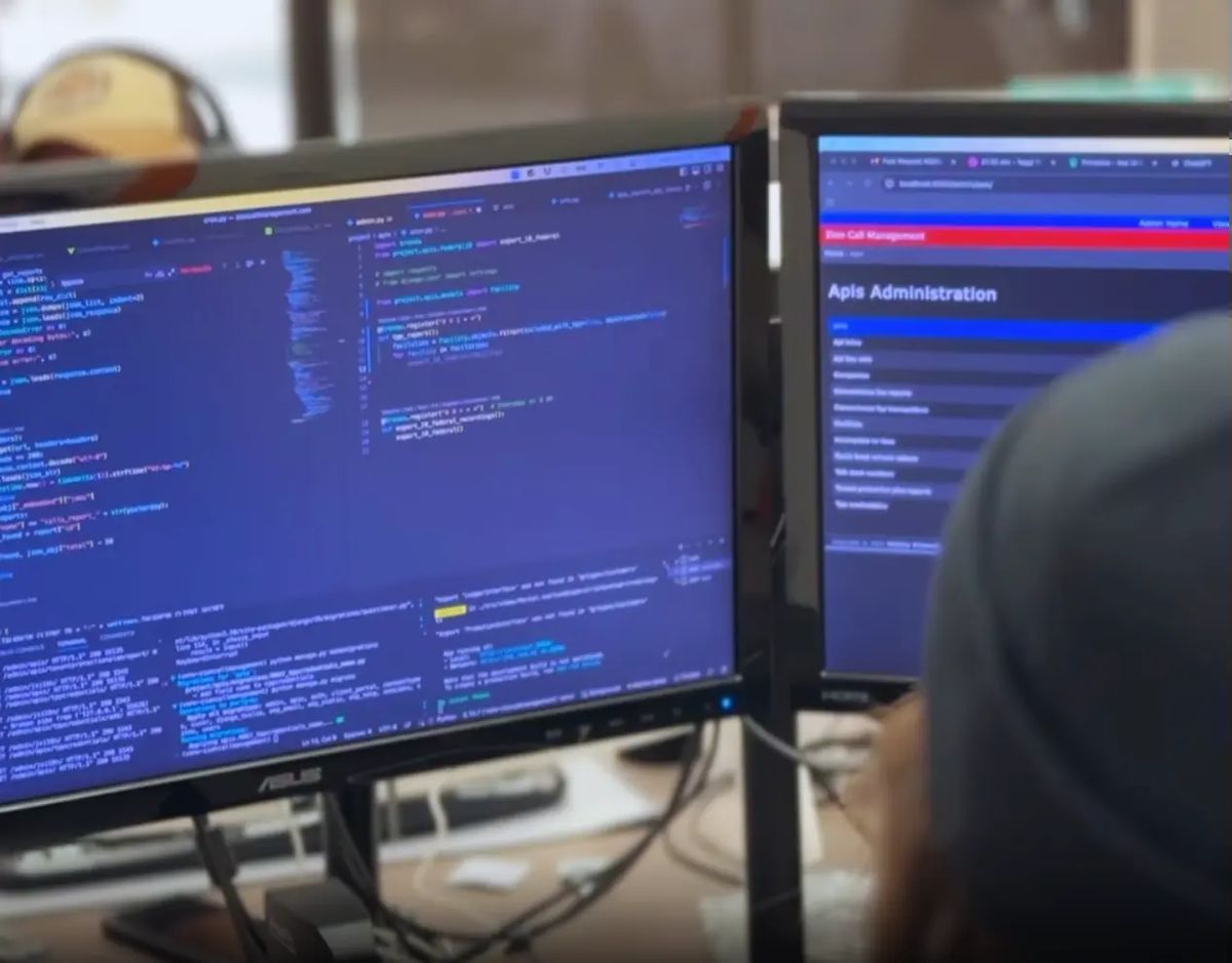 Virgo Development engineer working on API integration code on dual monitors