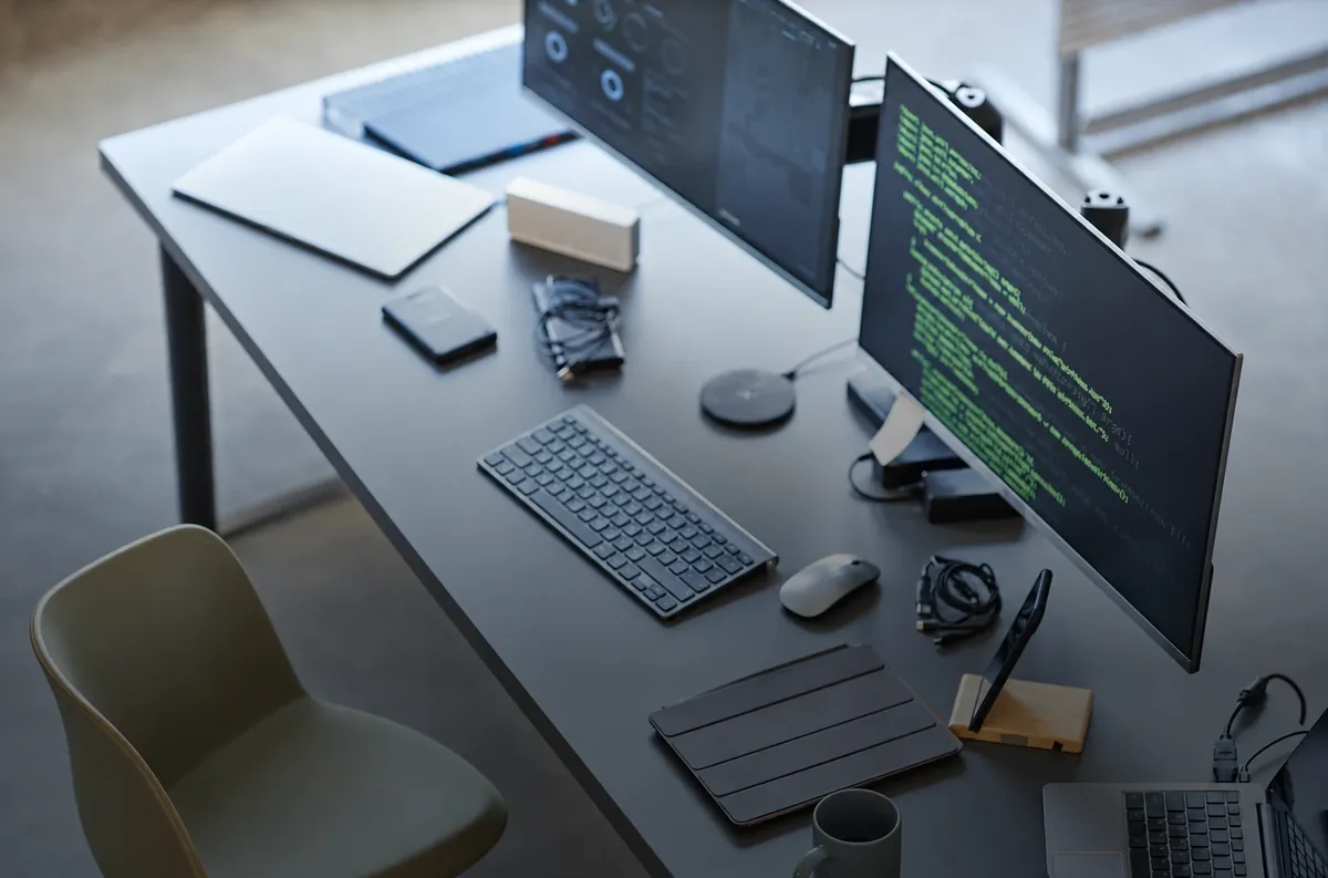 Software developer workstation with code on dual monitors